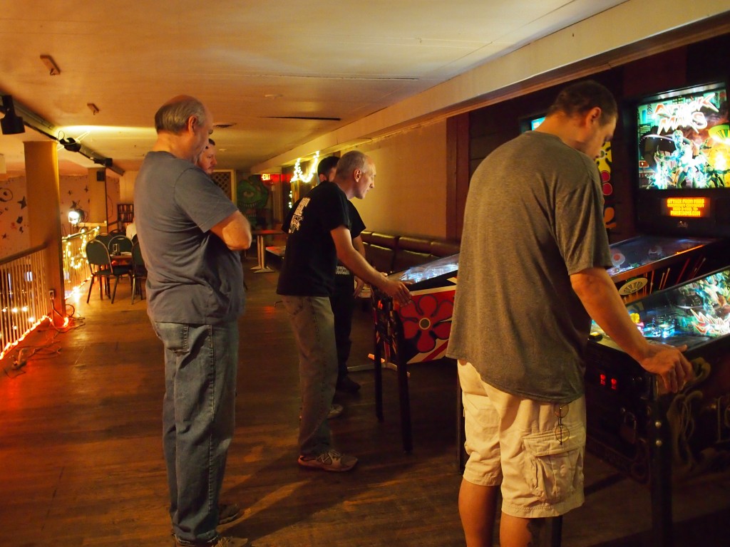 Chris playing Austin Powers while Terry and Mike watch.