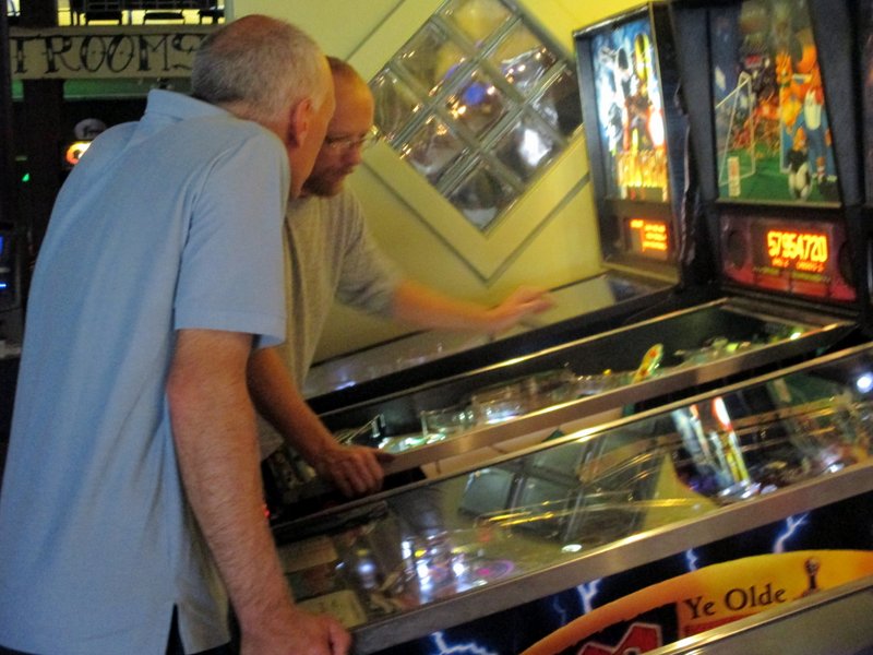 Derrick the pinball repairman consults with Chris.