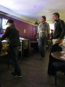 Bryan and Joseph watch Karen play a game of Simpsons.