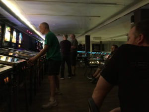 Mike watches as Chris plays The Simpsons Pinball Party.