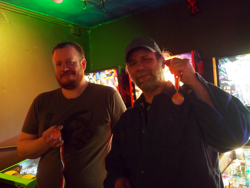 Mike and Pat hold up their medals.