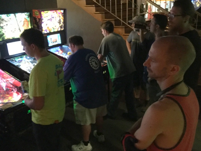 A crowd playing pinball.
