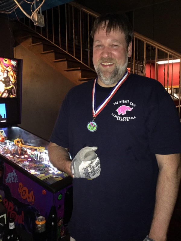 Jason wearing his medal and making a fist.