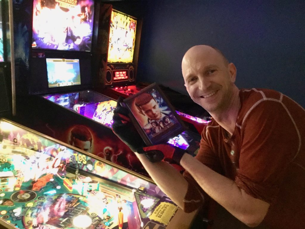 Josh leaning in front of Stranger Things and holding up his plaque.